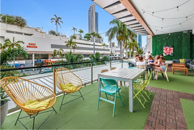 Backpackers socialising on a terrace at Tequila Sunrise Hostel Gold Coast